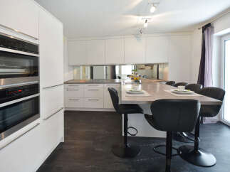 Experience modern living in this sleek kitchen featuring integrated ovens and ample cabinet space.