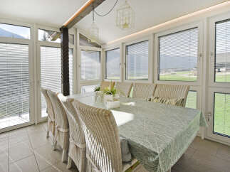 Enjoy breathtaking mountain views from this sun-drenched dining room, featuring a spacious table set for gatherings.
