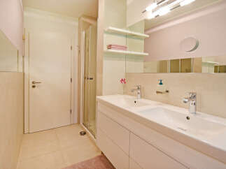 This modern bathroom features a spacious double vanity with sleek chrome fixtures and ample storage.