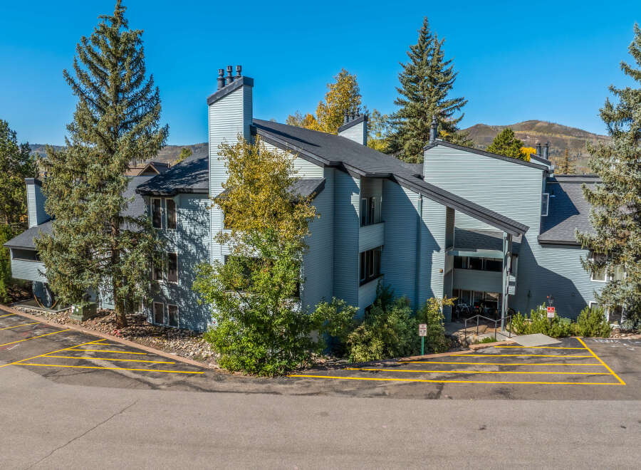 Discover this charming multi-unit property nestled amidst mature evergreen trees and vibrant autumn foliage.