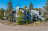 Discover this charming multi-unit property nestled amidst mature evergreen trees and vibrant autumn foliage.