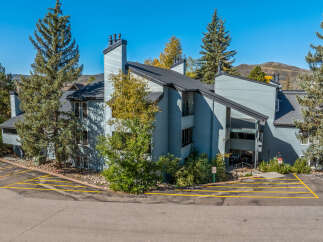 Discover this charming multi-unit property nestled amidst mature evergreen trees and vibrant autumn foliage.