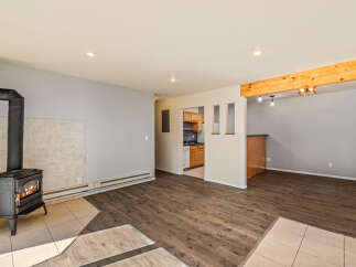 Cozy up by the fireplace in this inviting living space, featuring a charming wood-burning stove and warm, wood-look flooring.