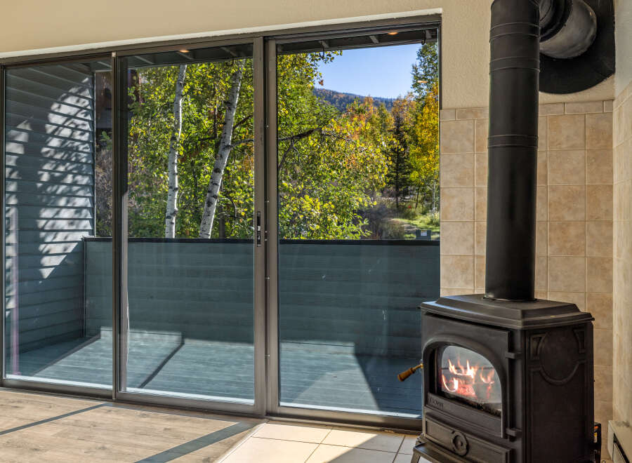 Cozy up by the fire in this inviting living space, featuring a classic black wood-burning stove with a glass door to admire the flames.