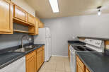 This kitchen features light wood cabinets providing ample storage space, complemented by dark countertops.