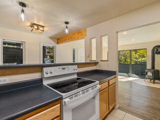 This kitchen features a white electric range with a black stovetop, complemented by dark countertops and light wood cabinetry.