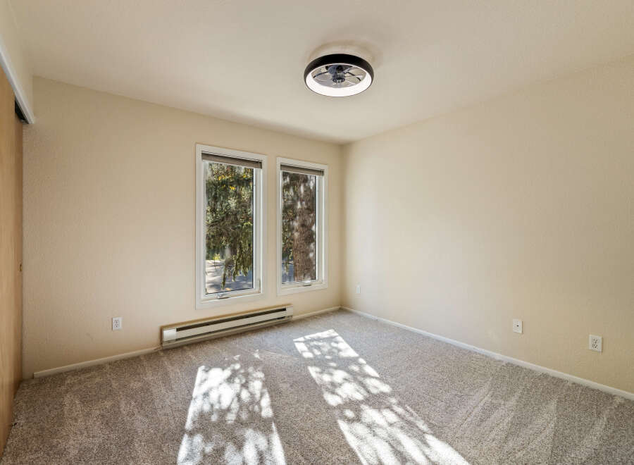 This empty room features a modern ceiling fan with light, perfect for year-round comfort.