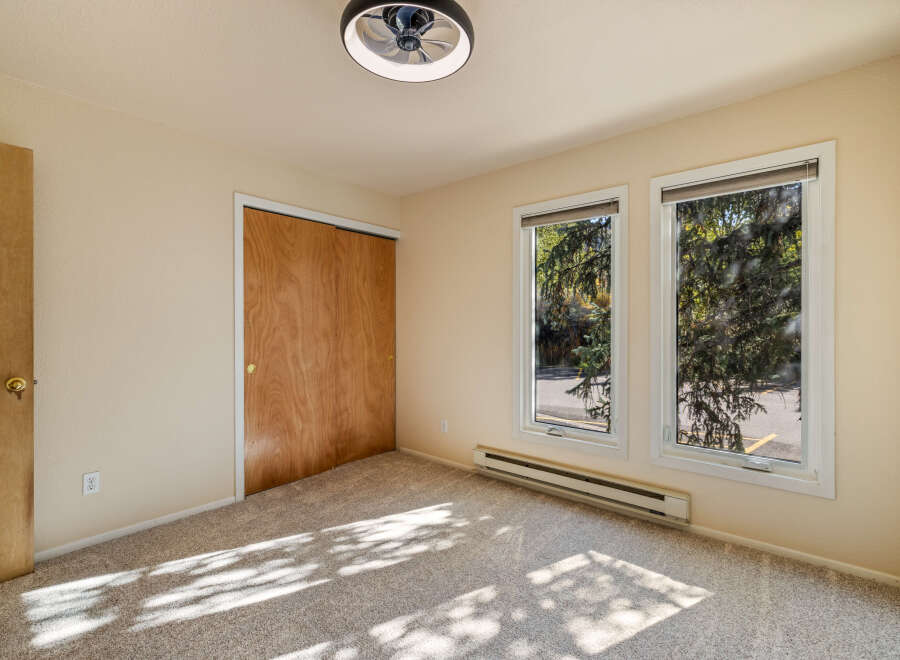This bedroom features a spacious closet with natural wood doors, perfect for ample storage.
