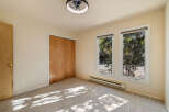 This bedroom features a spacious closet with natural wood doors, perfect for ample storage.