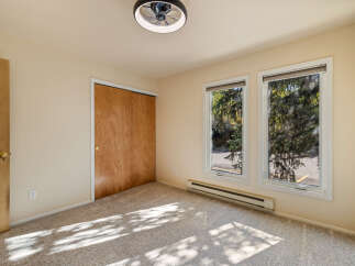 This bedroom features a spacious closet with natural wood doors, perfect for ample storage.