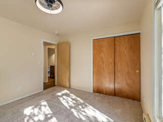 This bedroom features a light beige carpet and walls, creating a warm and inviting atmosphere.