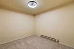 This empty room features neutral beige walls and plush carpeting, creating a blank canvas for your personal style.