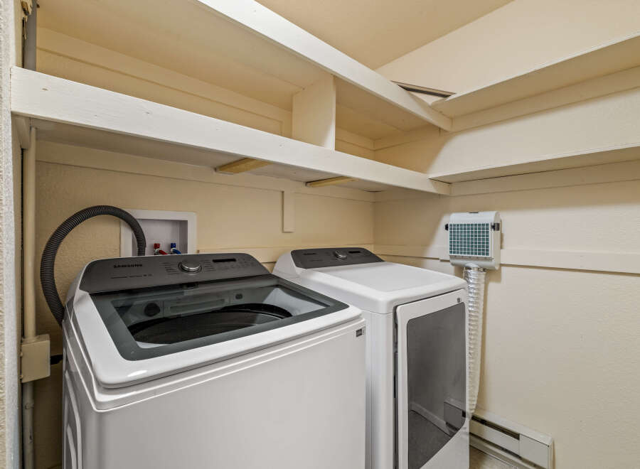 This laundry room features a Samsung top-load washer and a matching dryer, perfect for handling your family's laundry needs.