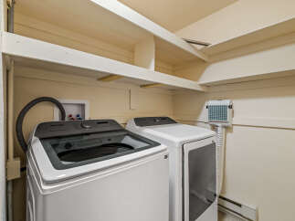 This laundry room features a Samsung top-load washer and a matching dryer, perfect for handling your family's laundry needs.