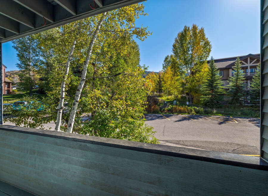 Enjoy the crisp mountain air from this charming balcony, offering a serene view of the surrounding aspen and pine trees.