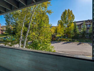Enjoy the crisp mountain air from this charming balcony, offering a serene view of the surrounding aspen and pine trees.