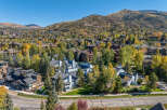 Experience the beauty of autumn in this stunning aerial view of a residential community nestled amidst vibrant fall foliage.