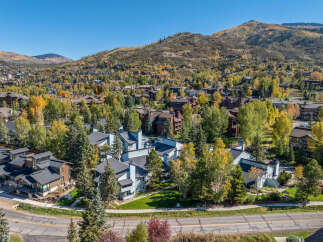 Experience the beauty of autumn in this stunning aerial view of a residential community nestled amidst vibrant fall foliage.