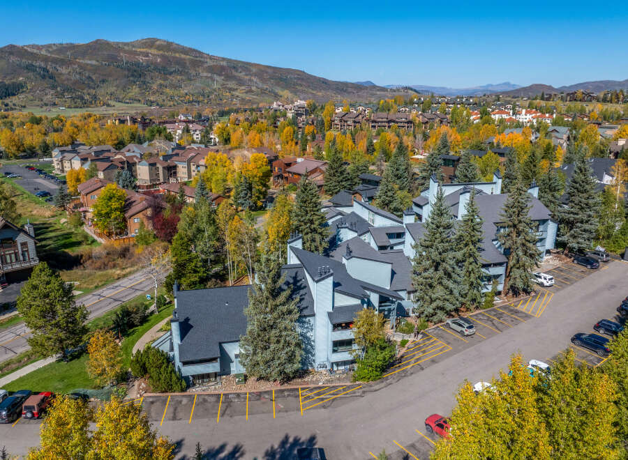 Experience the charm of autumn in this aerial view of a residential community nestled amidst vibrant fall foliage.
