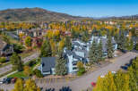 Experience the charm of autumn in this aerial view of a residential community nestled amidst vibrant fall foliage.