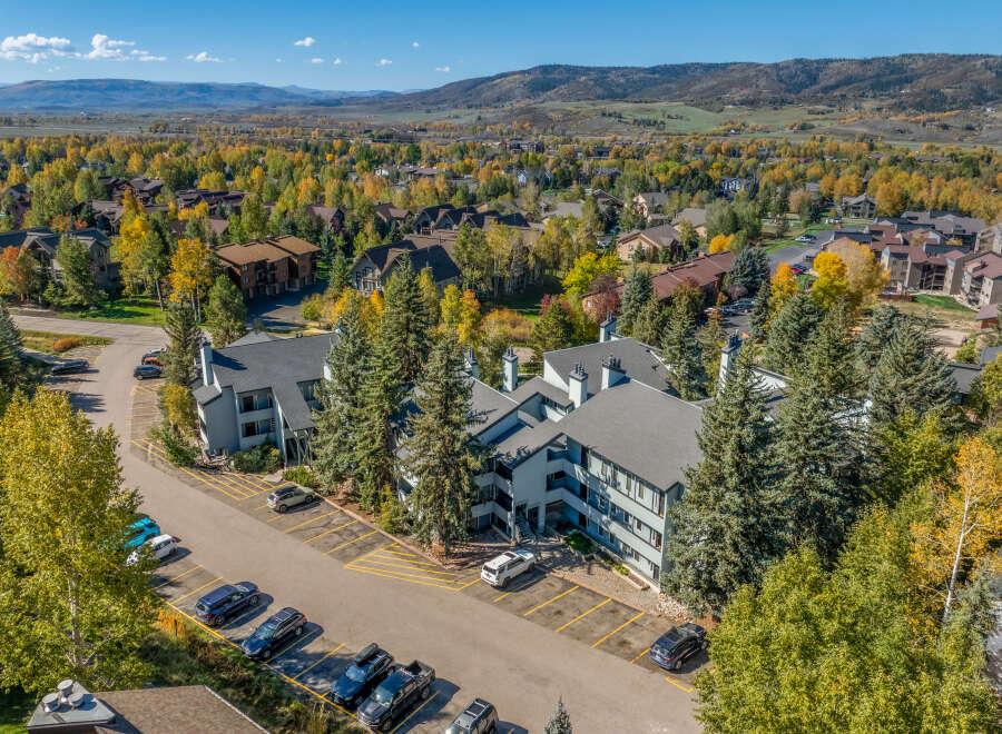 Experience the beauty of autumn in this aerial view of a residential community nestled amongst vibrant fall foliage.
