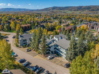 Experience the beauty of autumn in this aerial view of a residential community nestled amongst vibrant fall foliage.