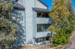Discover this charming property featuring a light blue siding exterior, complemented by mature trees and lush greenery.