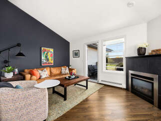 Step into this inviting living room featuring a warm leather sofa and a stylish accent chair, perfect for relaxation.