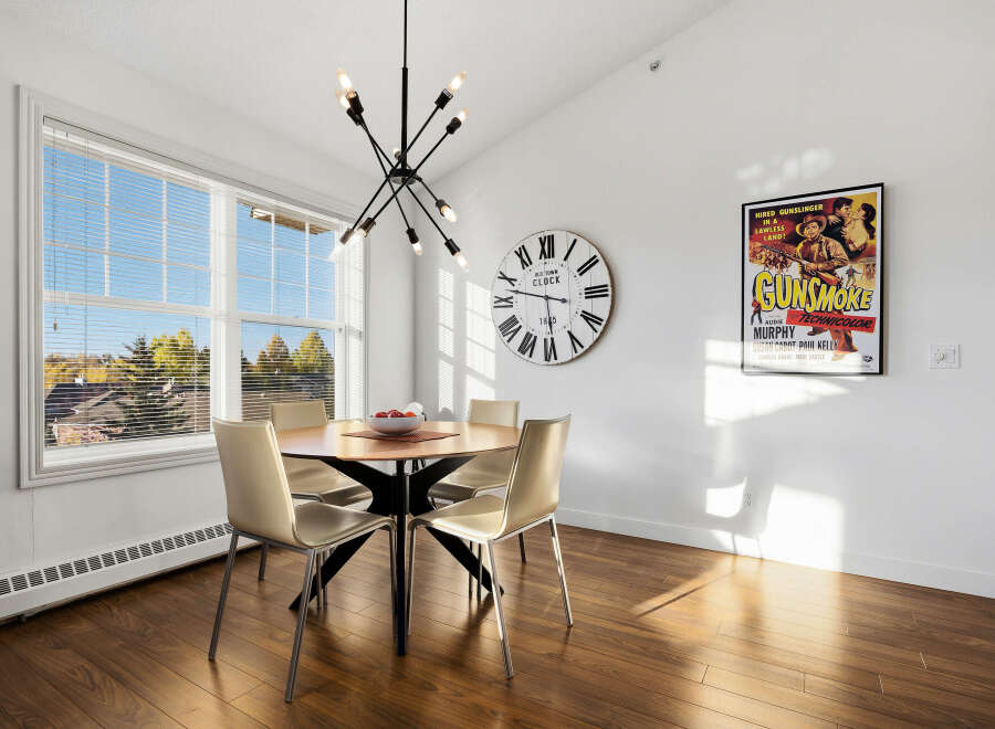 Bright and airy dining area featuring a round wooden table with four modern chairs, perfect for family meals.