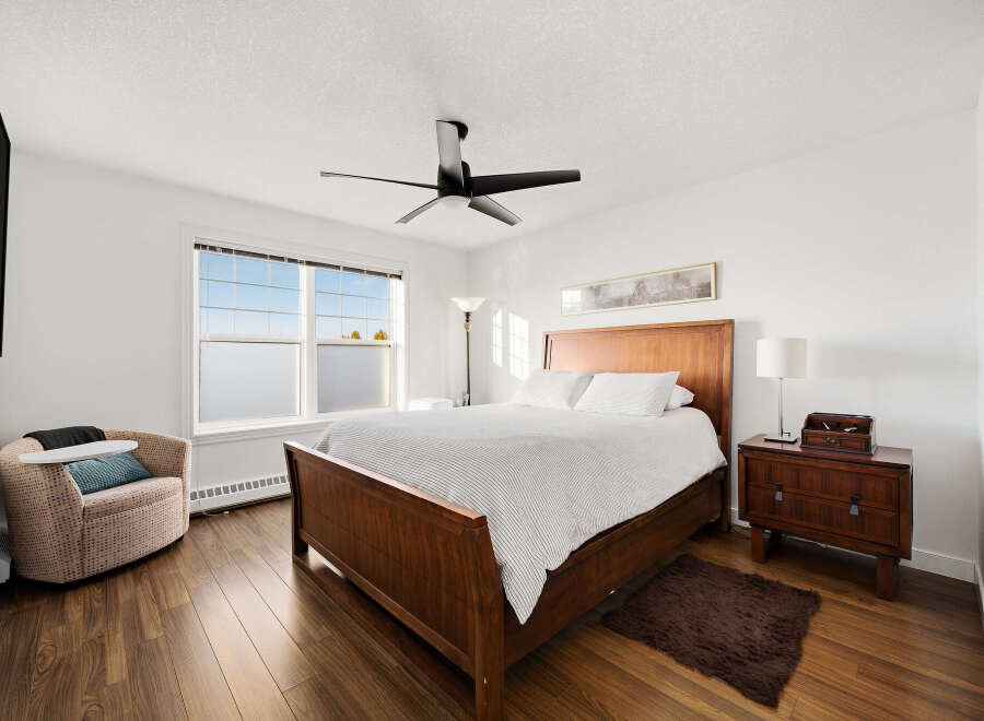 Experience comfort and style in this inviting bedroom, featuring a spacious wooden bed with crisp white linens.