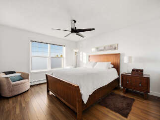 Experience comfort and style in this inviting bedroom, featuring a spacious wooden bed with crisp white linens.