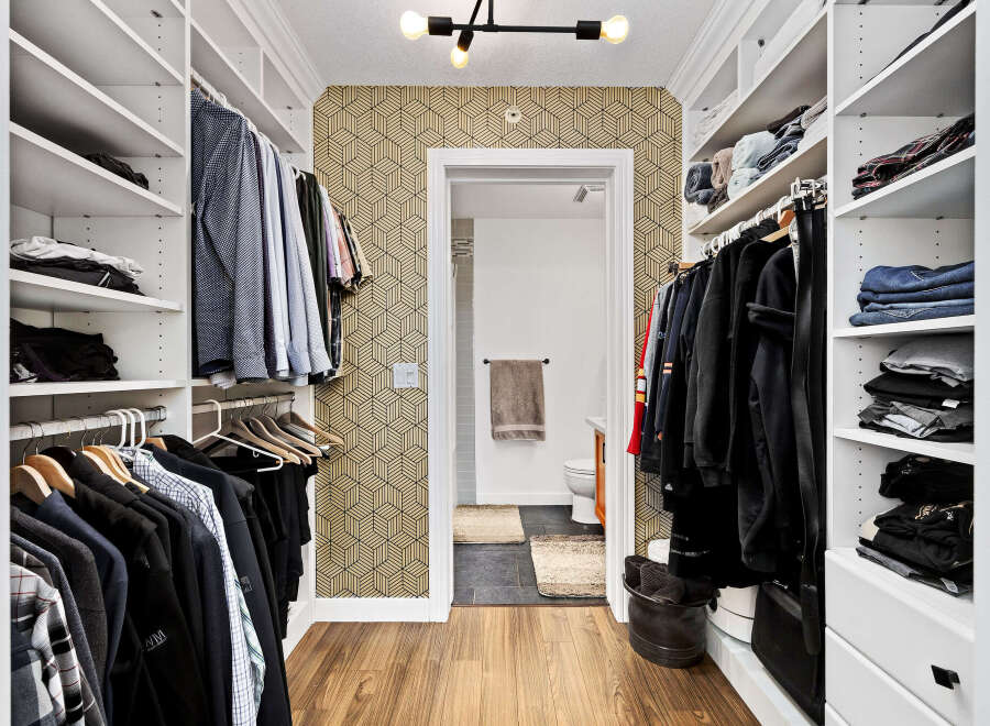 Step into this impeccably organized walk-in closet, featuring ample shelving and hanging space for all your clothing needs.