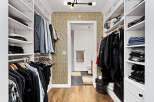 Step into this impeccably organized walk-in closet, featuring ample shelving and hanging space for all your clothing needs.
