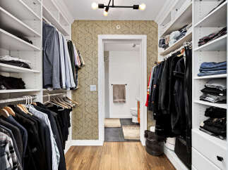 Step into this impeccably organized walk-in closet, featuring ample shelving and hanging space for all your clothing needs.