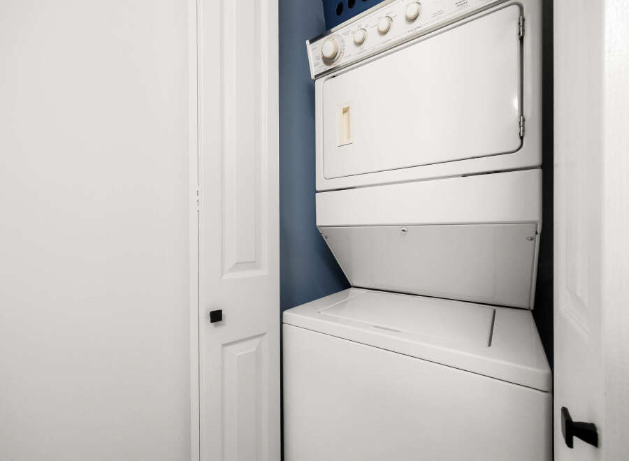 This laundry room features a stacked white washer and dryer unit, perfect for maximizing space in smaller homes or apartments.