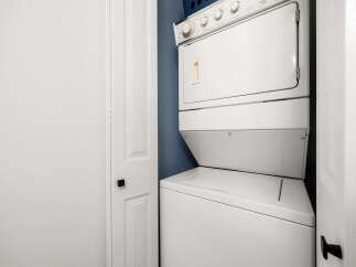 This laundry room features a stacked white washer and dryer unit, perfect for maximizing space in smaller homes or apartments.