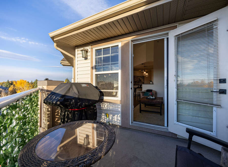 Enjoy outdoor living on this spacious balcony, complete with a covered grill and a charming bistro set perfect for morning coffee or evening relaxation.