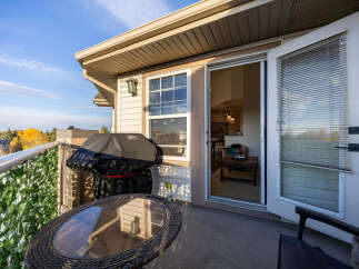 Enjoy outdoor living on this spacious balcony, complete with a covered grill and a charming bistro set perfect for morning coffee or evening relaxation.