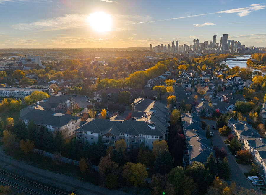 Experience the vibrant autumn colors surrounding this modern apartment complex, offering a serene living environment.