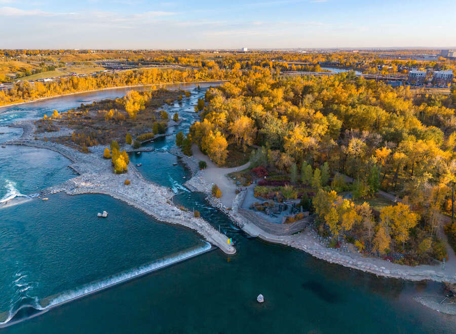 Experience the vibrant beauty of autumn from this stunning aerial view, showcasing a picturesque riverfront property.