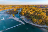 Experience the vibrant beauty of autumn from this stunning aerial view, showcasing a picturesque riverfront property.
