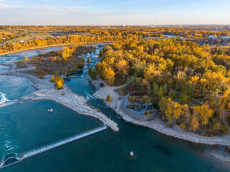 Experience the vibrant beauty of autumn from this stunning aerial view, showcasing a picturesque riverfront property.