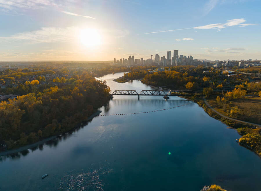Experience breathtaking autumn views with this stunning aerial shot capturing the vibrant fall foliage surrounding a serene river.