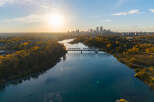 Experience breathtaking autumn views with this stunning aerial shot capturing the vibrant fall foliage surrounding a serene river.