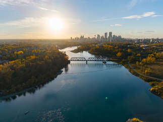 Experience breathtaking autumn views with this stunning aerial shot capturing the vibrant fall foliage surrounding a serene river.