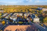 Experience modern living in this aerial view of a contemporary apartment complex nestled amidst vibrant autumn foliage.