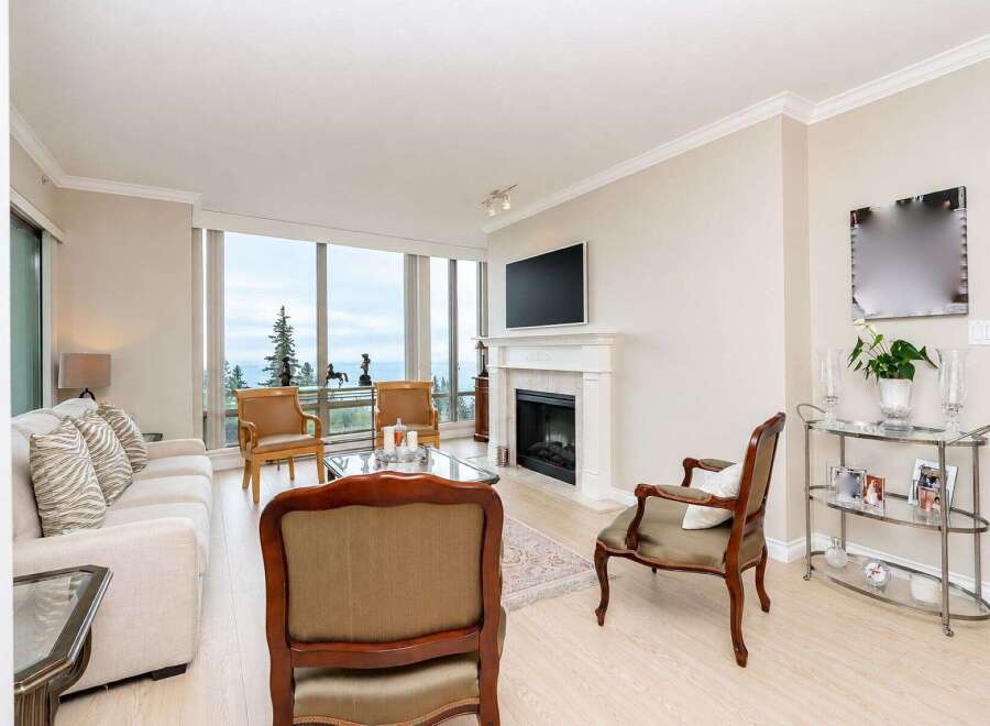 Experience breathtaking ocean views from this elegant living room, featuring a cozy fireplace and a large picture window.
