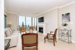 Experience breathtaking ocean views from this elegant living room, featuring a cozy fireplace and a large picture window.