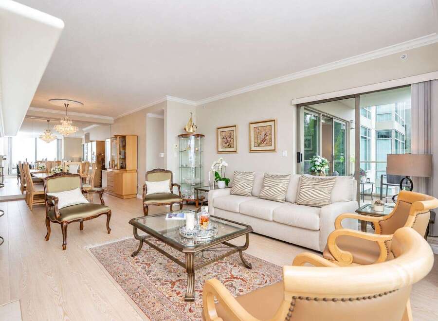 Experience elegant living in this spacious open-concept condo, featuring a formal dining area with crystal chandeliers and a bright living room.
