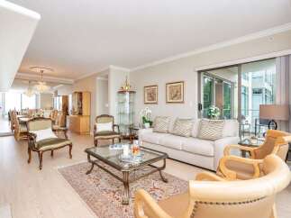 Experience elegant living in this spacious open-concept condo, featuring a formal dining area with crystal chandeliers and a bright living room.